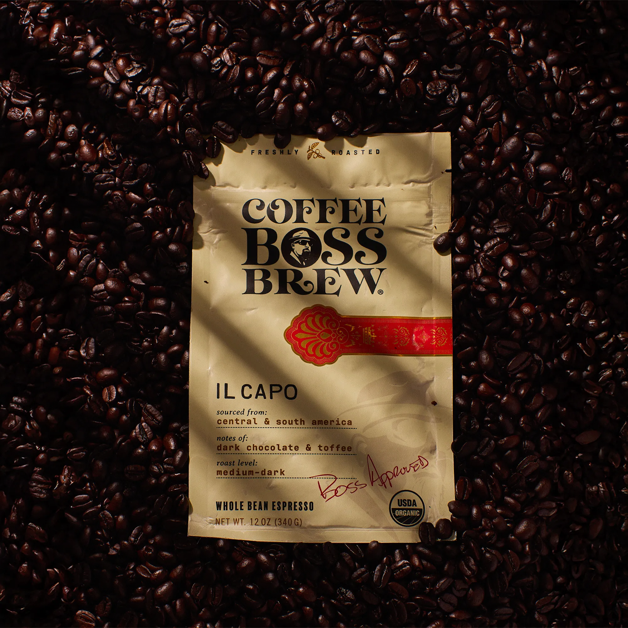 Coffee Boss Brew Il Capo blend bag surrounded by coffee beans